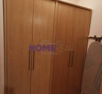 In the 2-room apartment, you can see a wardrobe with a wooden decor and an ironing board.