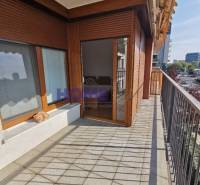 A balcony with tiles, wooden windows, and a view of the surroundings in a 2-room apartment.
