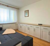 A room with a sofa, furniture, and a floor with wooden decor in a 3-room apartment.