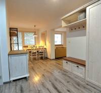 Interior of a 3-room apartment with a wooden decor floor and a dining table.