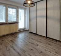 A room with a wooden decor floor and built-in wardrobes in a 3-room apartment.