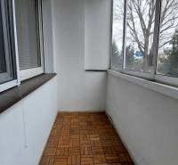 Glazed loggia with wood-decor flooring in a 3-room apartment.
