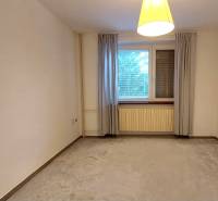 A spacious room with curtains and a carpet in a 3-room apartment.