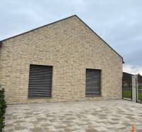 A family house on Fialkova Street in Tomášov with a brick facade and a paved courtyard.