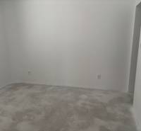 A room with white walls and a plain carpet in a family house.