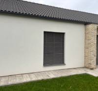 The exterior of a family house on Fialkova Street in Tomášov with brick cladding and a lawn.