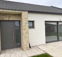Family house on Fialkova in Tomášov with brick cladding and spacious glass doors.