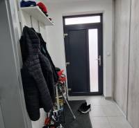 Entrance hall of a family house, with tiles, a coat rack, and a shoe shelf.