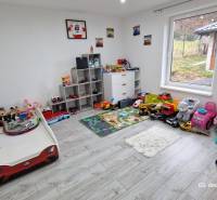 Children's room in a family house with toys, a bed, and a wooden decor floor.