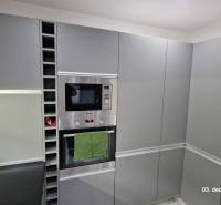A kitchen in a family house with gray cabinets, a built-in microwave, and an oven.