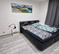 Bedroom in a family house with a bed, a nightstand, and a wooden decor floor.