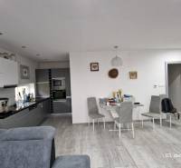Interior of a family house with a kitchen, dining table, and floor with wooden decor.