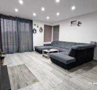 Living room in a family house with a sofa, table, and wooden decor flooring.