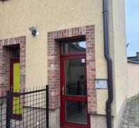 In Senec, you will find offices in a brick building with red doors.