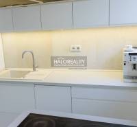 A kitchen with white cabinets and a coffee maker in a 3-room apartment.