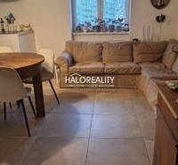 Living room of a 3-room apartment with a sofa, dining table, and tiled floor.