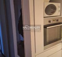 Interior of a 3-room apartment with a wooden decor floor and a white dresser.