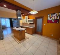 A kitchen with light tiles and a wooden decor floor in a 4-room apartment.