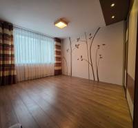 A spacious room with wall decoration, wooden decor flooring, 4-room apartment.