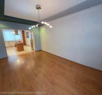 Dining room and kitchenette in a 4-room apartment with wood-patterned flooring.