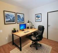 Office corner in a 4-room apartment with a desk and wooden decor flooring.