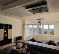 Living room in a two-room apartment with light walls and windows, furnished with furniture.