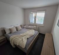 A bedroom in a 2-room apartment with a bed, nightstands, and wall decor.