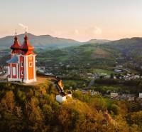 Calvary on the hill with a panorama of Banská Štiavnica, surrounded by agricultural and forest lands.