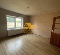A room with a large window and a wooden decor floor in a family house.