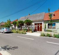 A family house in Malacky with a garden, cars parked on the street in front of the house.