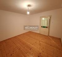 An empty room in a family house with a wooden decor floor and a simple light fixture.