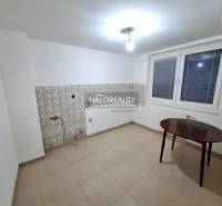 A room in a family house with white walls, a window, and tiles.