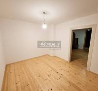 An empty room in a family house with a wood-patterned floor and simple lighting.