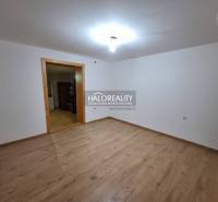Interior of a family house with a wood-patterned floor and white walls.
