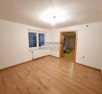 A room in a family house with a wooden decor floor and white walls.