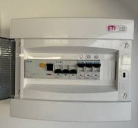 Electrical panel in the garage with circuit breakers and a switch.