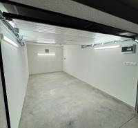 A spacious garage interior with a concrete floor and white walls.