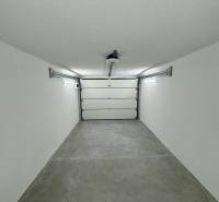 White wall and floor in the Garage space with an automatic door.