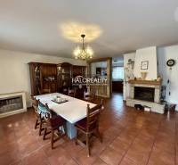 Dining room of a family house with a fireplace, ceramic floor, wooden furniture.
