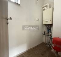 Technical room in a family house with a boiler and a floor with a wooden decor.