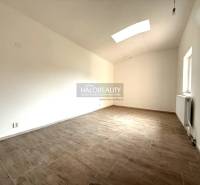 A spacious room with a wood-patterned floor in a family house.