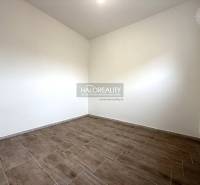 A room with a wooden decor floor in a family house, light walls, radiator.