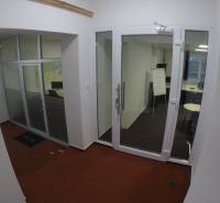 Glass doors and glass-walled offices with red carpet in the offices.