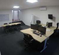 Offices with desks, computers, chairs, and air conditioning, without wooden floor decor.