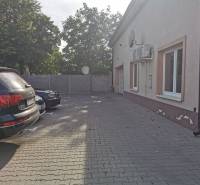 Parking lot near the offices on Šamorínska Street in Senec with cars and trees in the background.