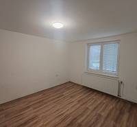 An empty room with a wooden floor, part of a 3-room apartment.
