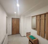A hallway in a 3-room apartment with a wardrobe wall and ceramic flooring.