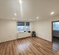 A room with a wooden decor floor and a plastic chair in a 3-room apartment.