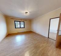 A room in a family house with a wooden decor floor and a large window.