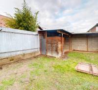 A garden at a family house on SNP Street in the village of Veľké Leváre with a metal fence.
